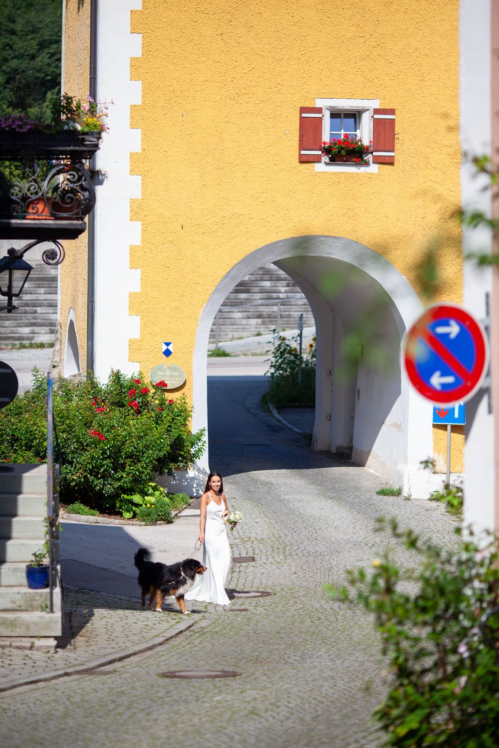 A sequence of images showing a yellow building facade with an arched passageway and cobblestone courtyard.