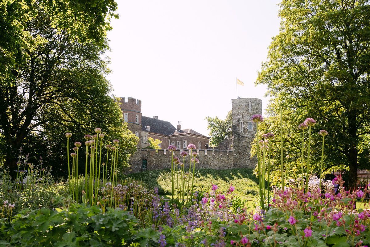 Burg Frankenberg in Aachen mit Blumen im Vordergrund.