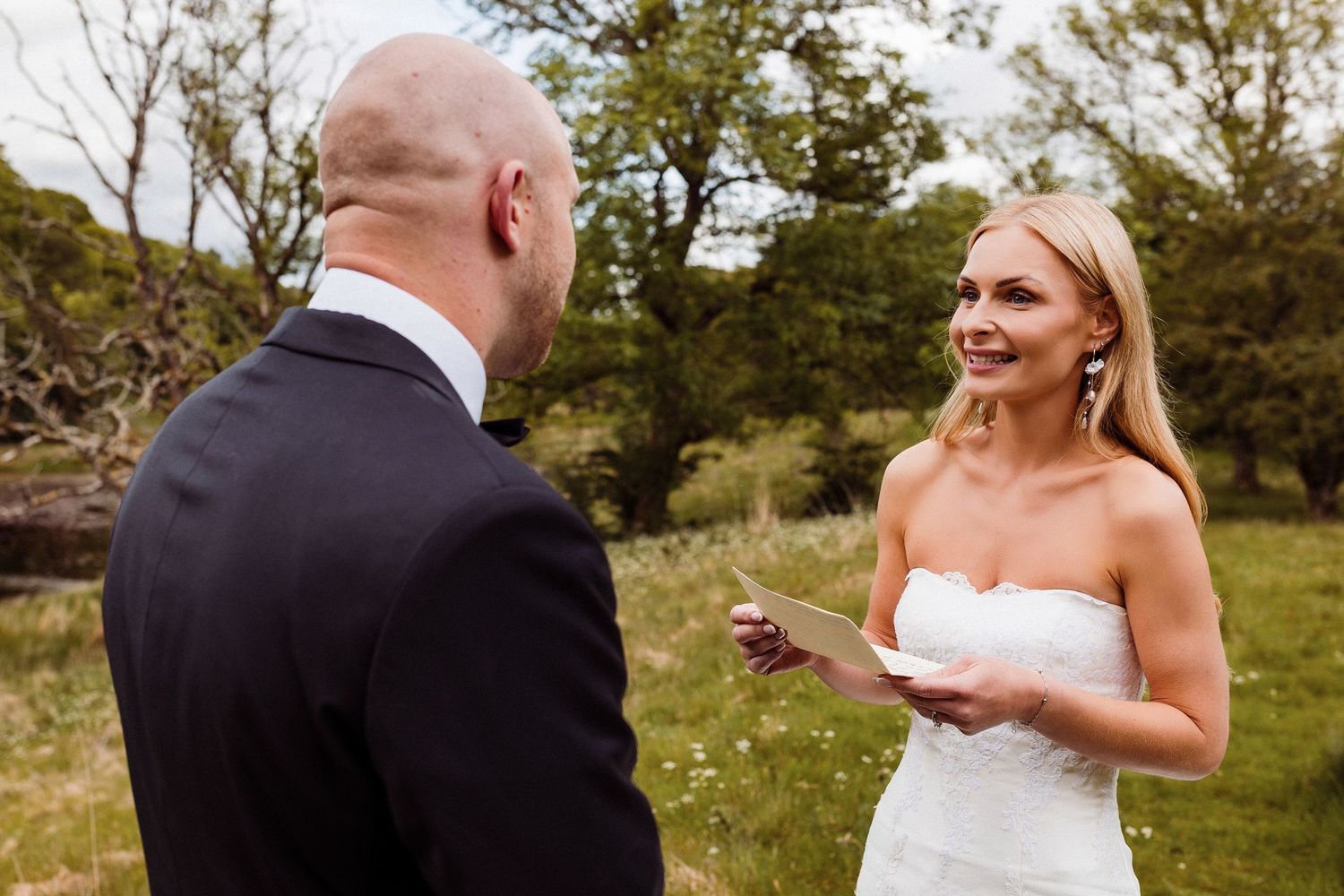 A happy couple shares romantic moments during their outdoor wedding photoshoot in a natural setting.