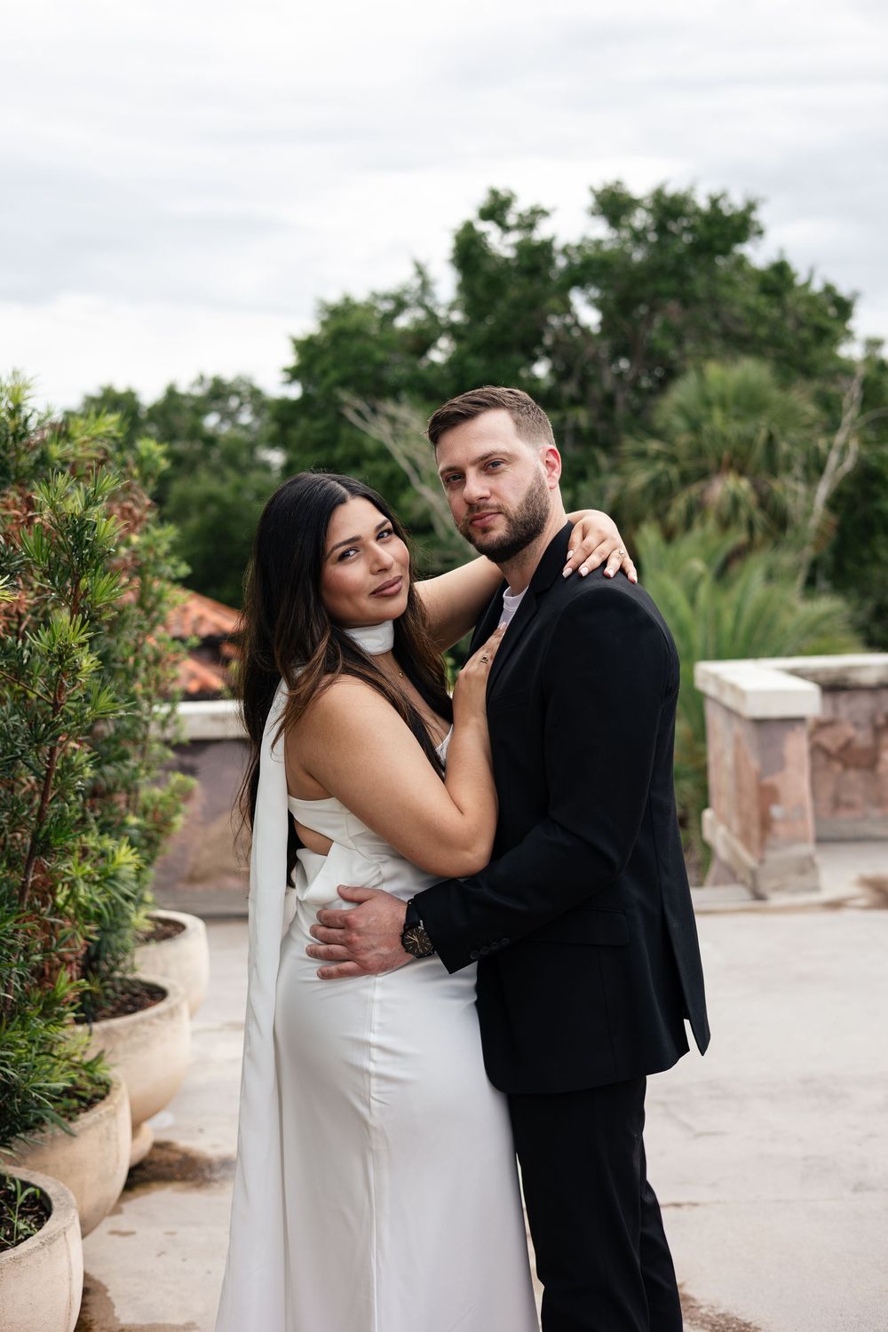 A couple shares romantic moments in a garden setting during their wedding photo session.