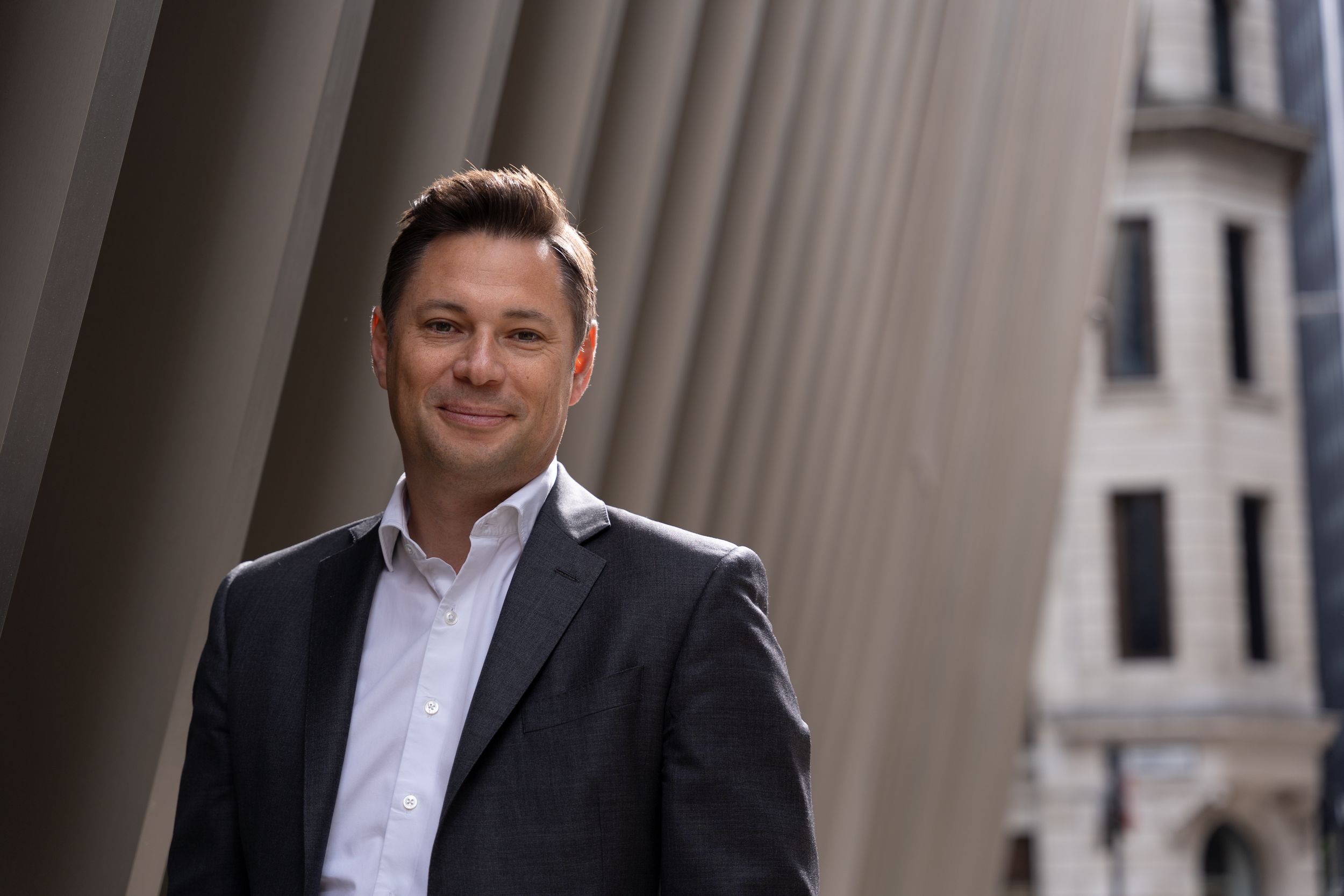 Male CEO stands in a street in The City on a business staff photoshoot in London.