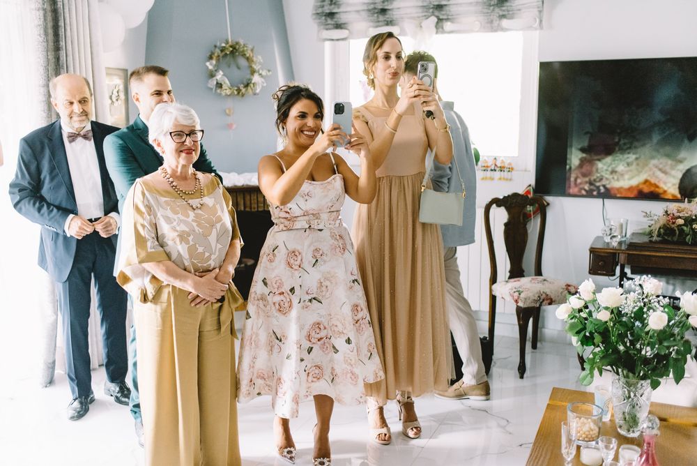 A collage of candid wedding moments showing guests and bridal party members in beige and floral dresses dancing and celebrating.