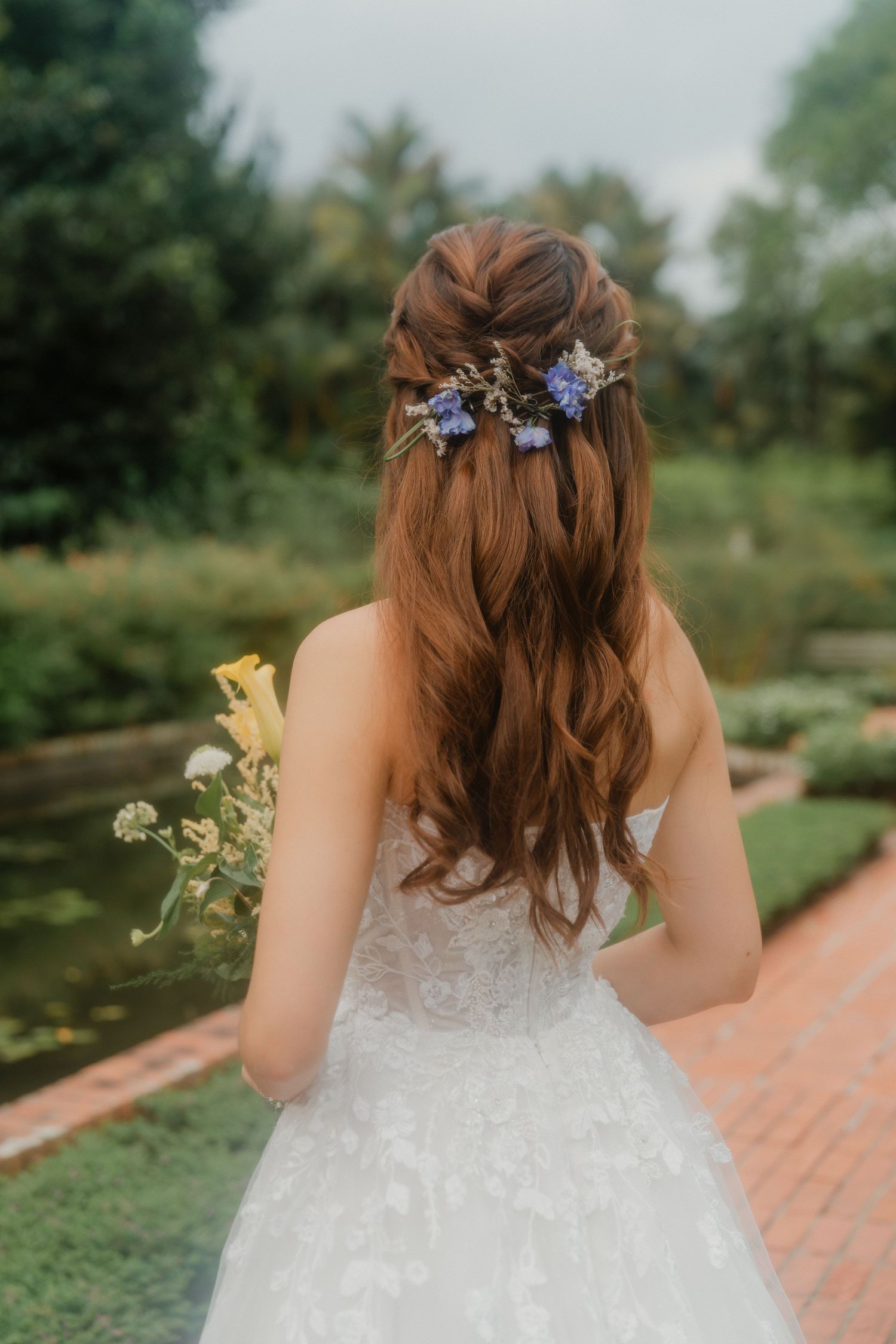 Elegant bridal hairstyle with delicate floral hair accessories in a garden setting.