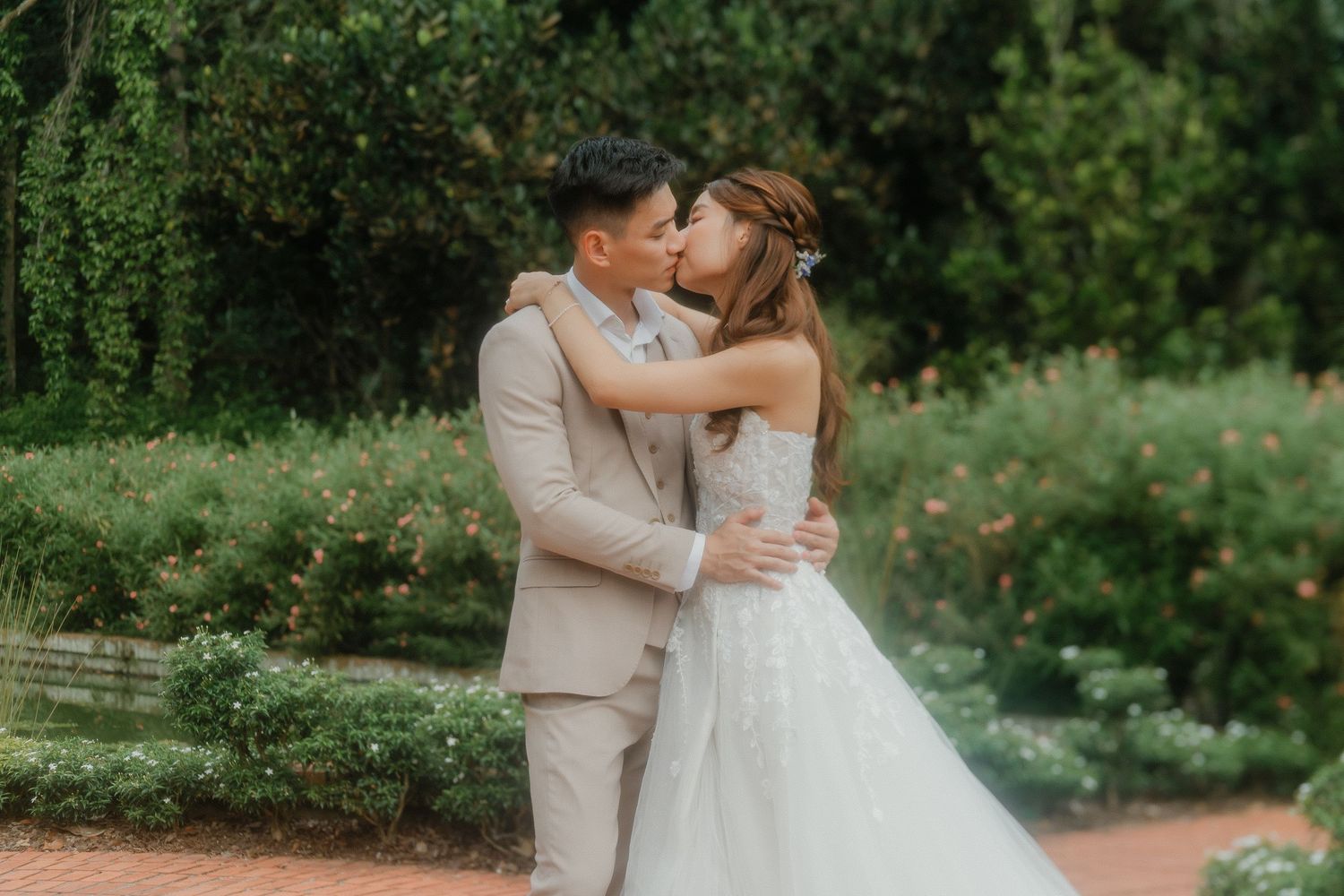 A romantic embrace between newlyweds in a lush garden setting on their wedding day.