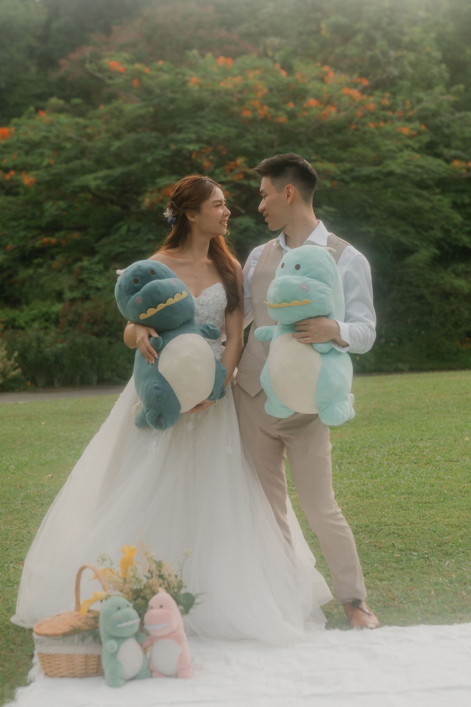 Romantic outdoor engagement photo session with couple holding plush teddy bears in white and casual attire.