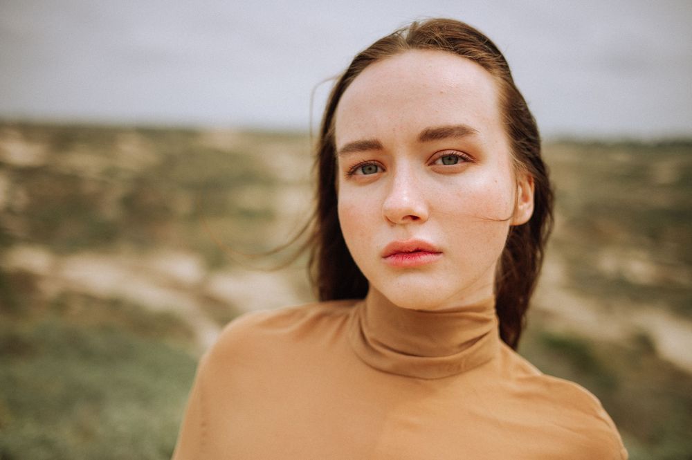 Close-up portrait shots against a natural coastal backdrop.