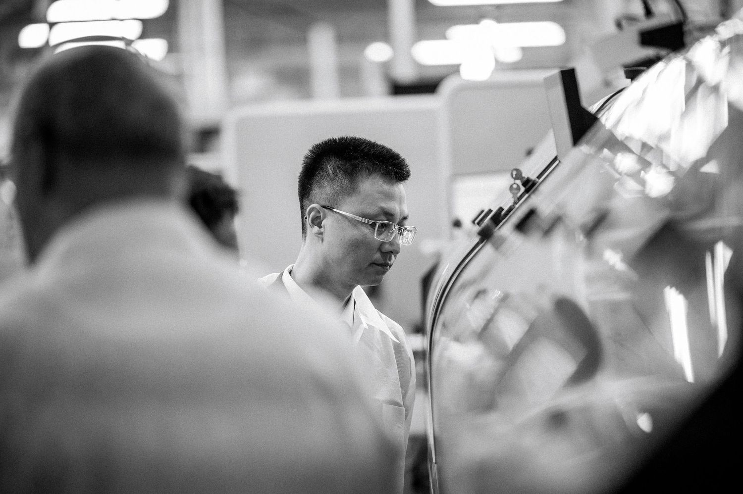 Ingénieur en blouse observant une ligne de production ; reportage photo corporate en Centre‑Val  de  Loire