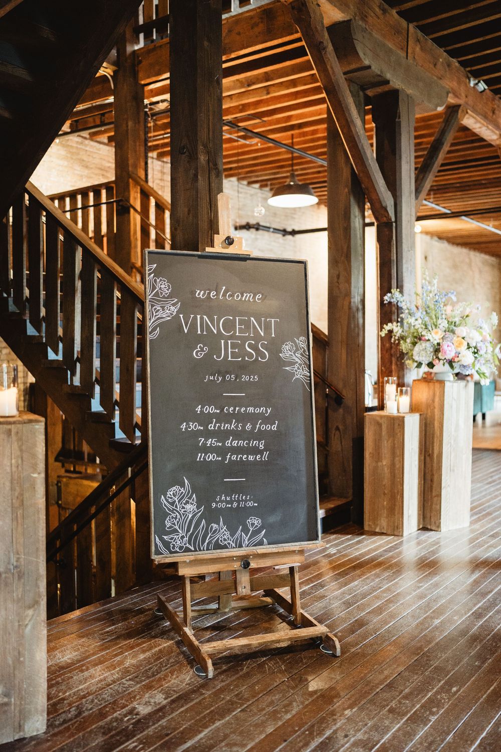 Rustic wooden interior with chalkboard wedding signs displayed along wooden beams and posts.