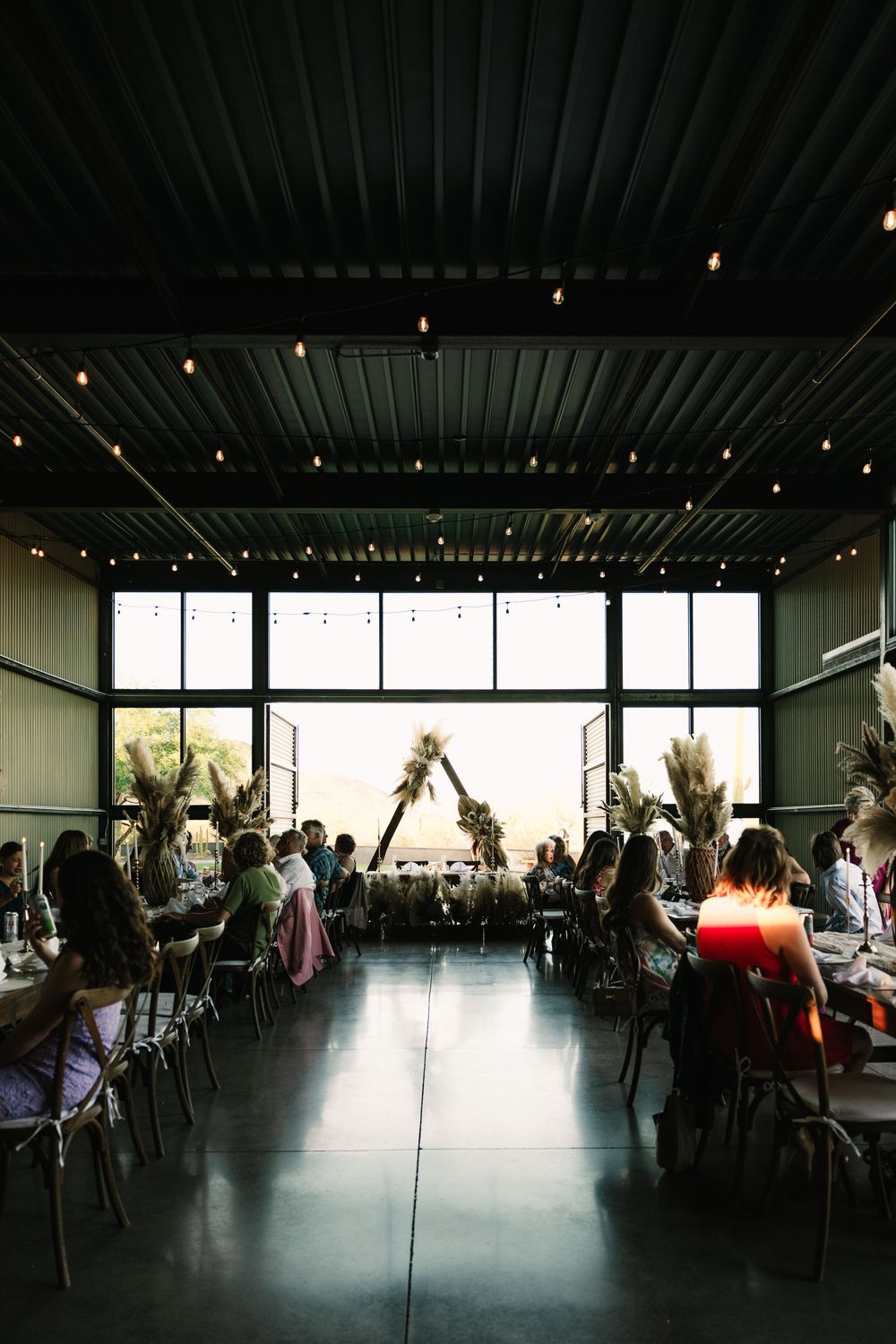 Large modern reception venue with floor-to-ceiling windows and ambient lighting.