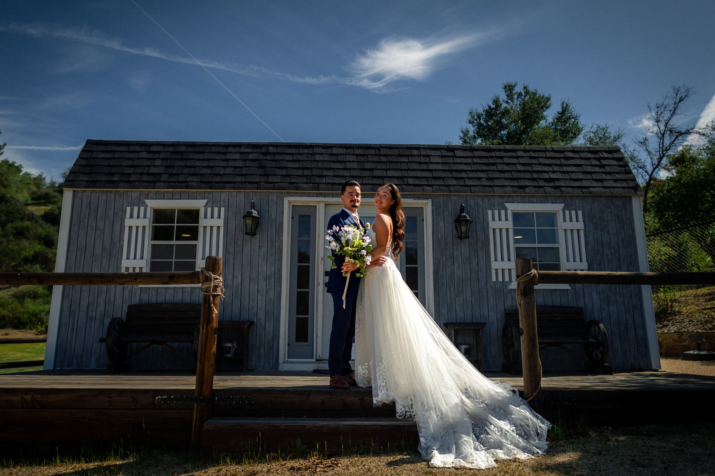 Wedding venue exterior with rustic gray buildings and wooden accents.