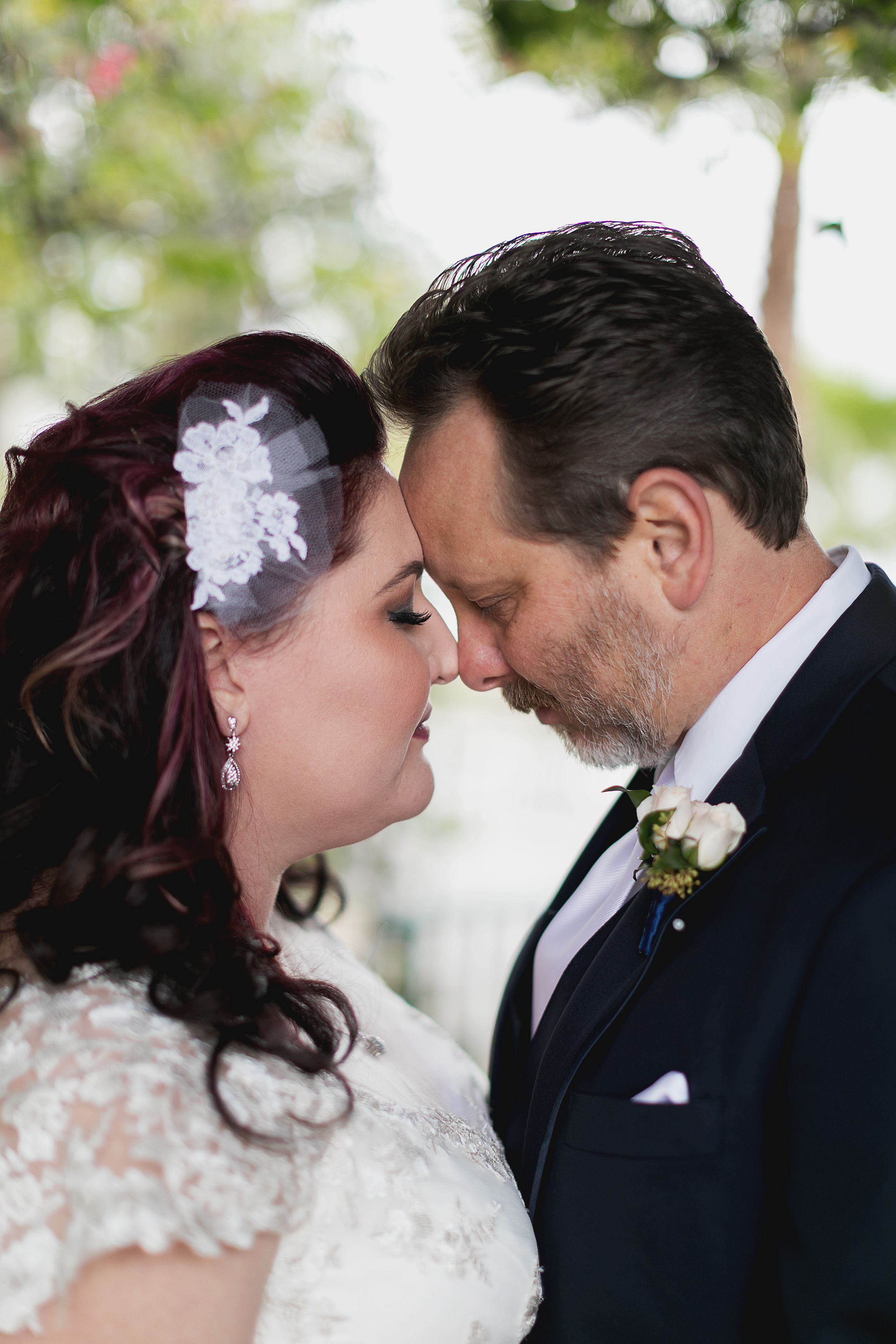 An intimate close-up of a wedding couple sharing a romantic moment outdoors.