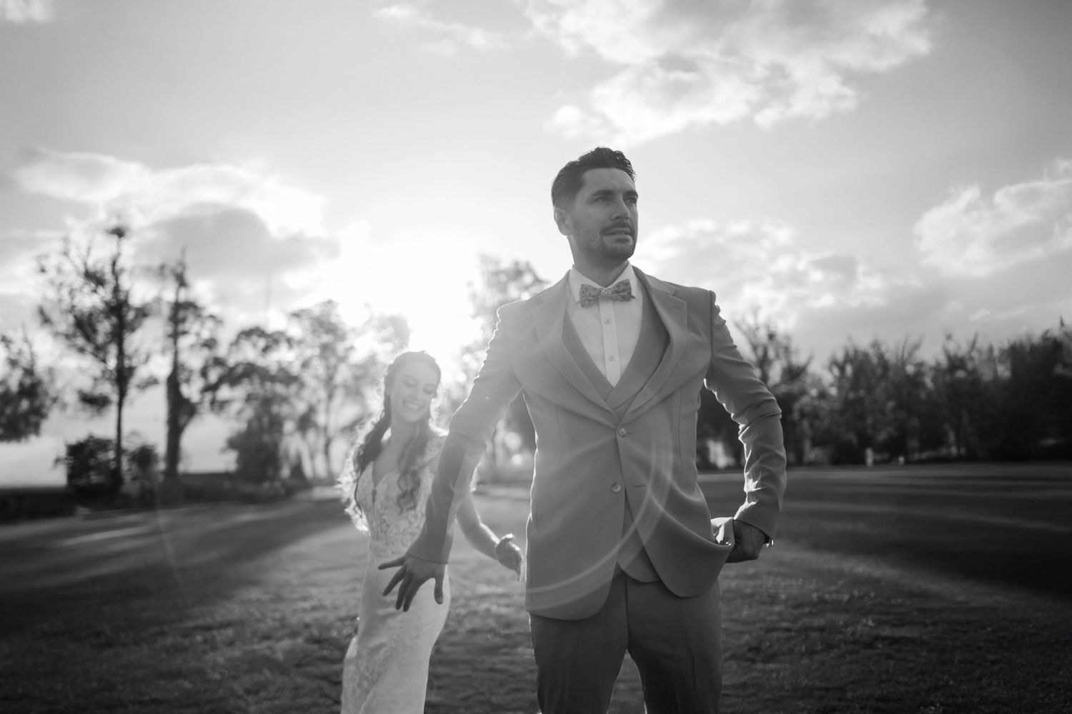 Romantic sunset wedding photos captured in black and white on an open field.