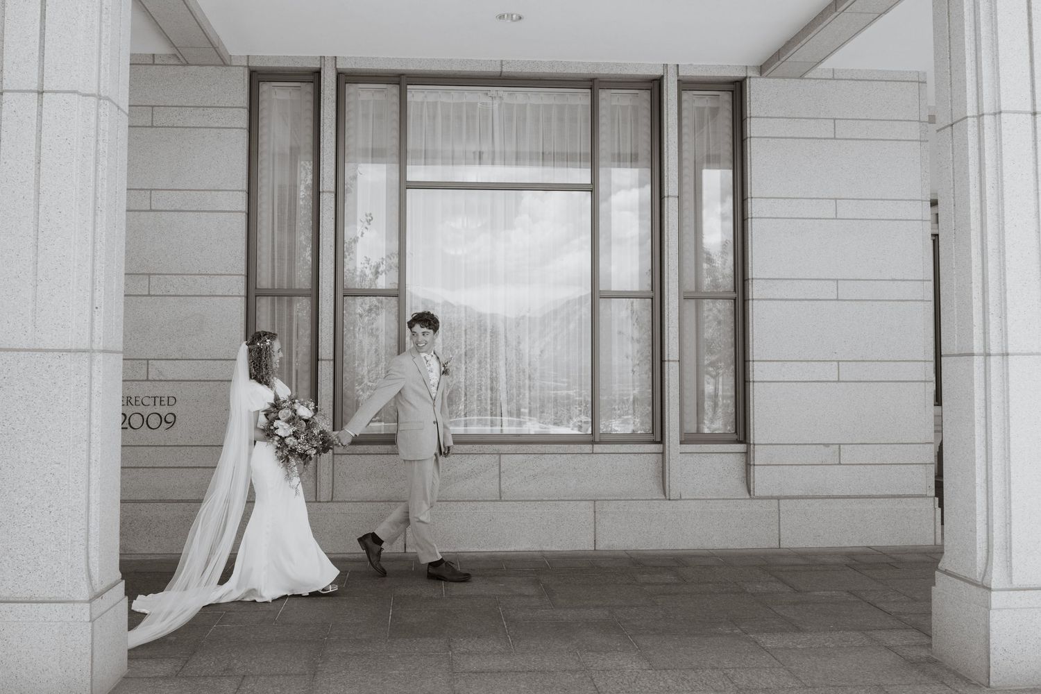 Des Moines Iowa Summer wedding at the temple: bride and groom walking hand in hand enjoying the day.