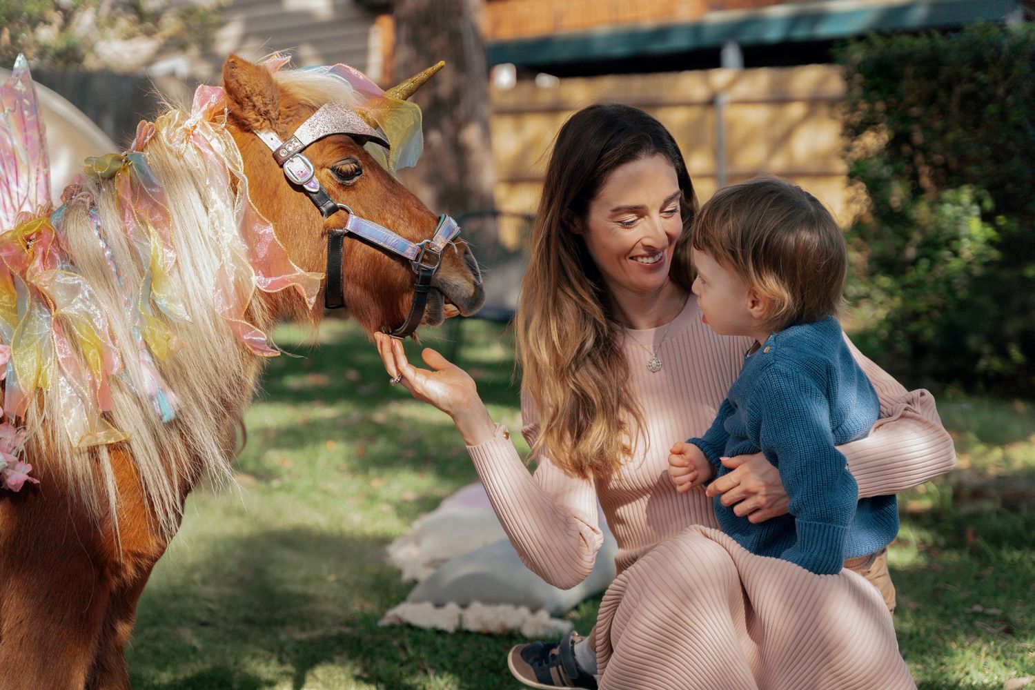 Mom and her son looking at a unicorn during a unicorn photoshoot on a birthday party in Sydney Lane Cove