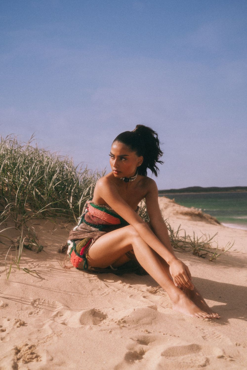 Candid beach portrait with sand dunes and ocean in background.