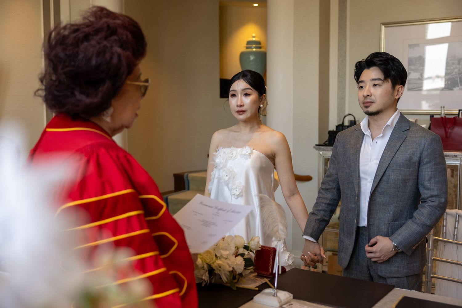 An emotional wedding ceremony moment as couple exchanges rings with officiant present.