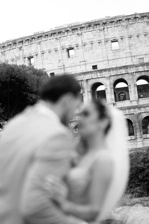 Black and white artistic wedding portraits captured against the dramatic backdrop of the Colosseum in Rome.