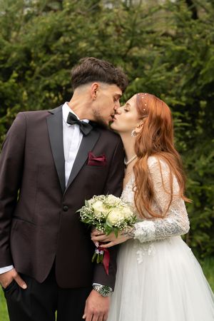 Romantic wedding photo sequence showing couple sharing intimate moments in a garden setting with greenery backdrop.