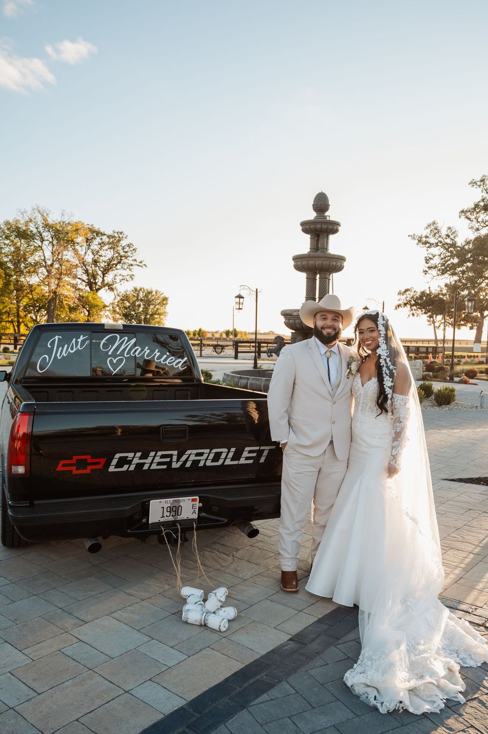 A romantic wedding photo series featuring a white pickup truck with 'Just Married' written on the tailgate at sunset.