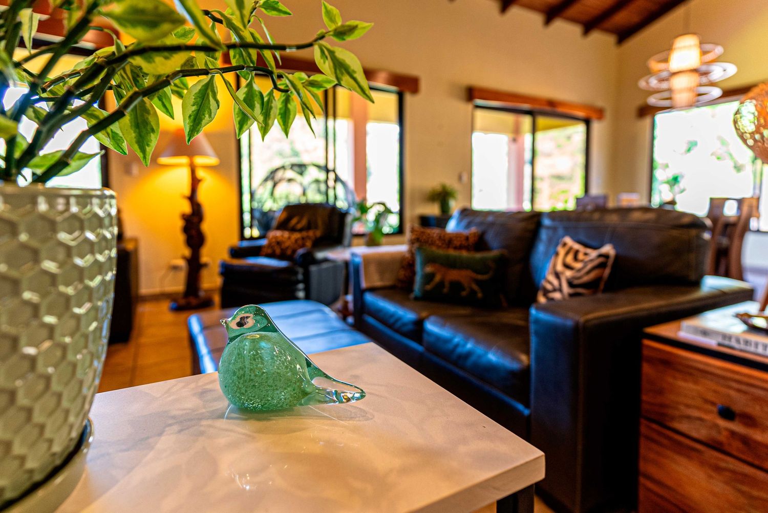 Elegant living room with large windows, natural light, and tropical stylish furniture in a  Costa Rica home