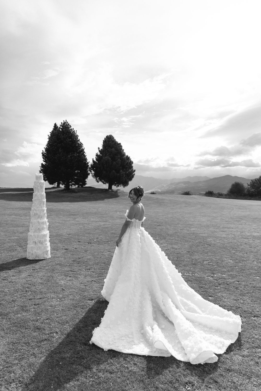 Bride in wedding gown with long train at outdoor destination wedding