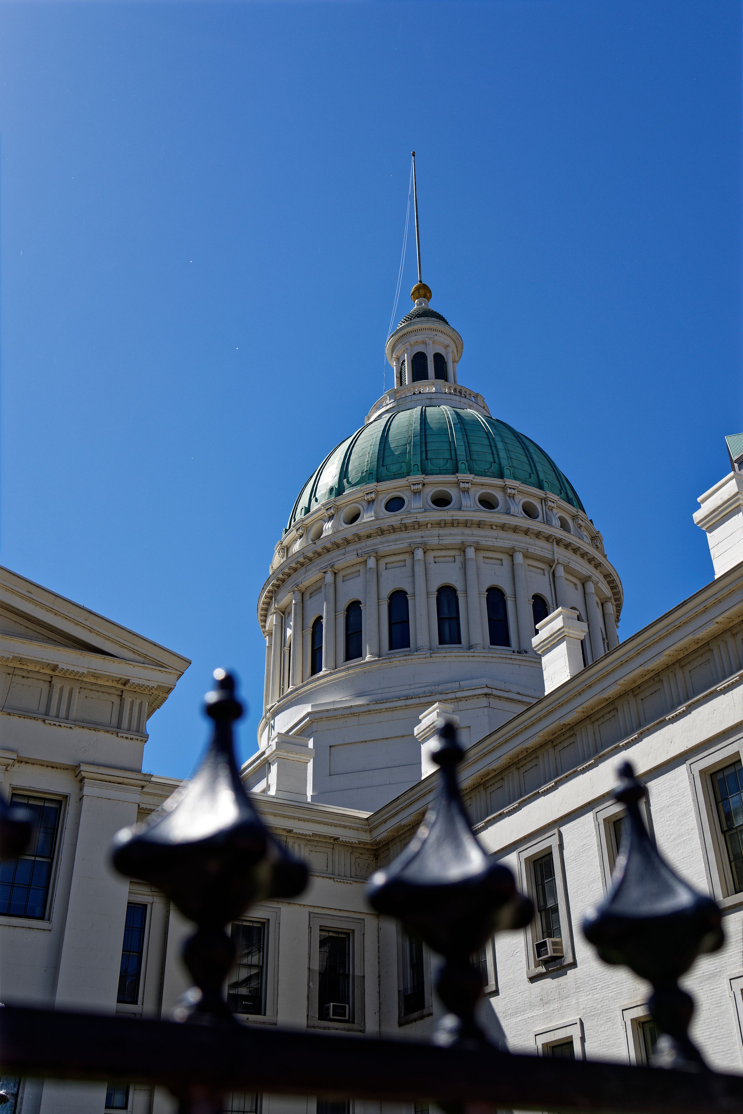 Historic domed St Louis, MO government building with ornate architecture against bright blue sky.