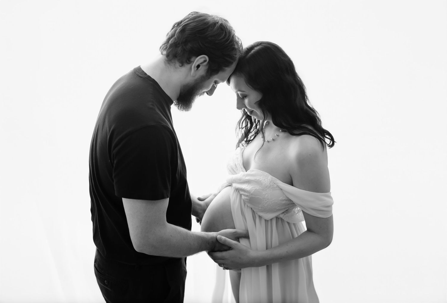 Charlottesville photographer, maternity, newborn, family, baby, pregnant couple in intimate pose, gray clothing, and smiling at belly