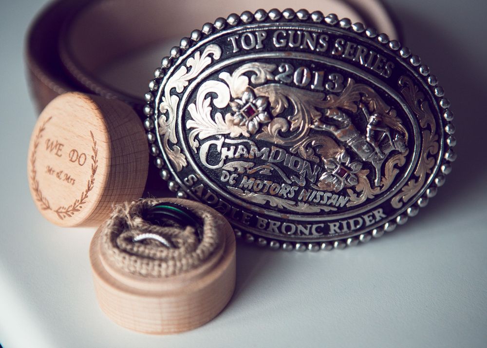 A collection of vintage-style metal and leather belt buckles displayed in a row with decorative western designs and patterns.