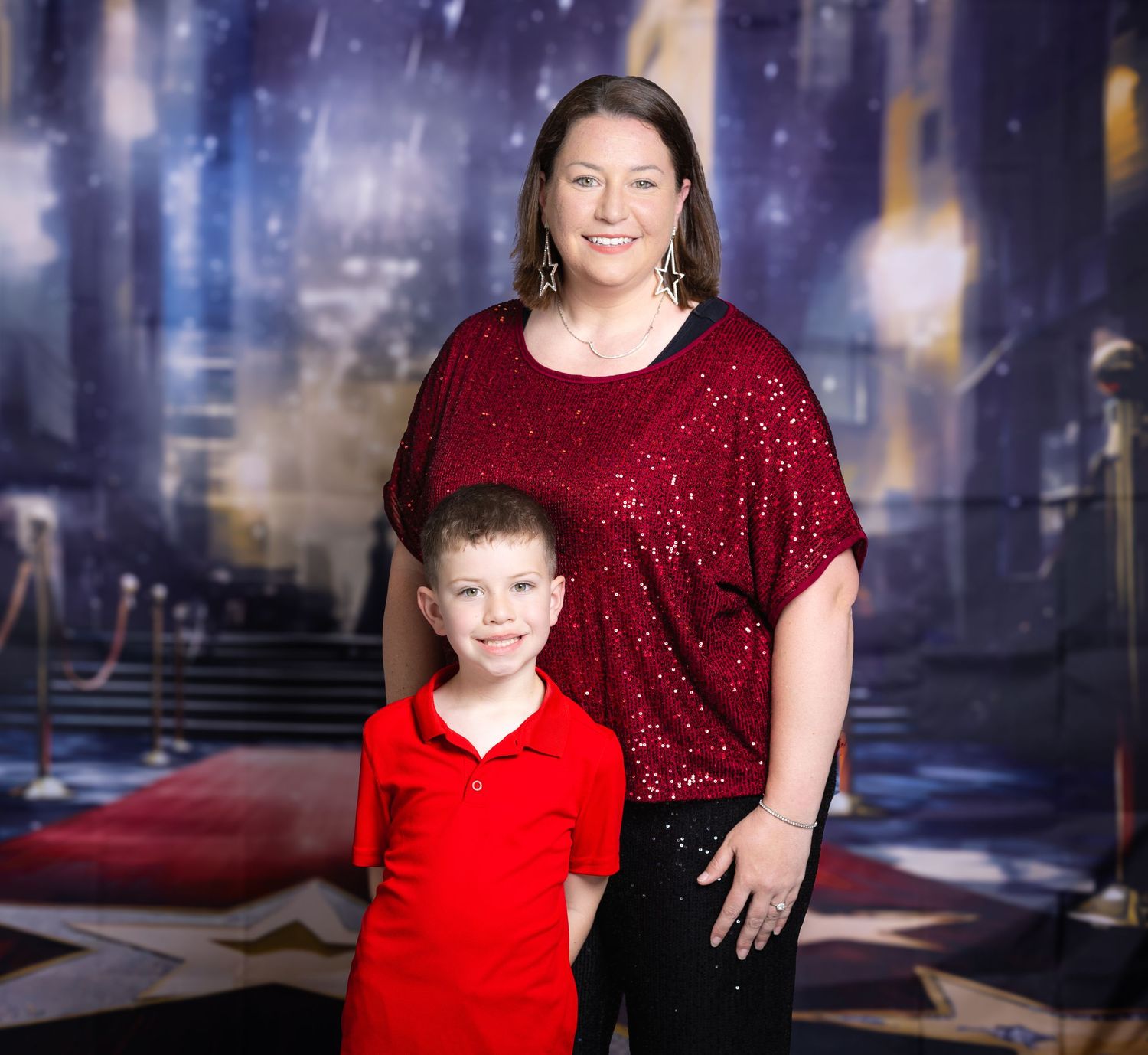 Festive studio portrait against a sparkling blue background with glittery red outfits.