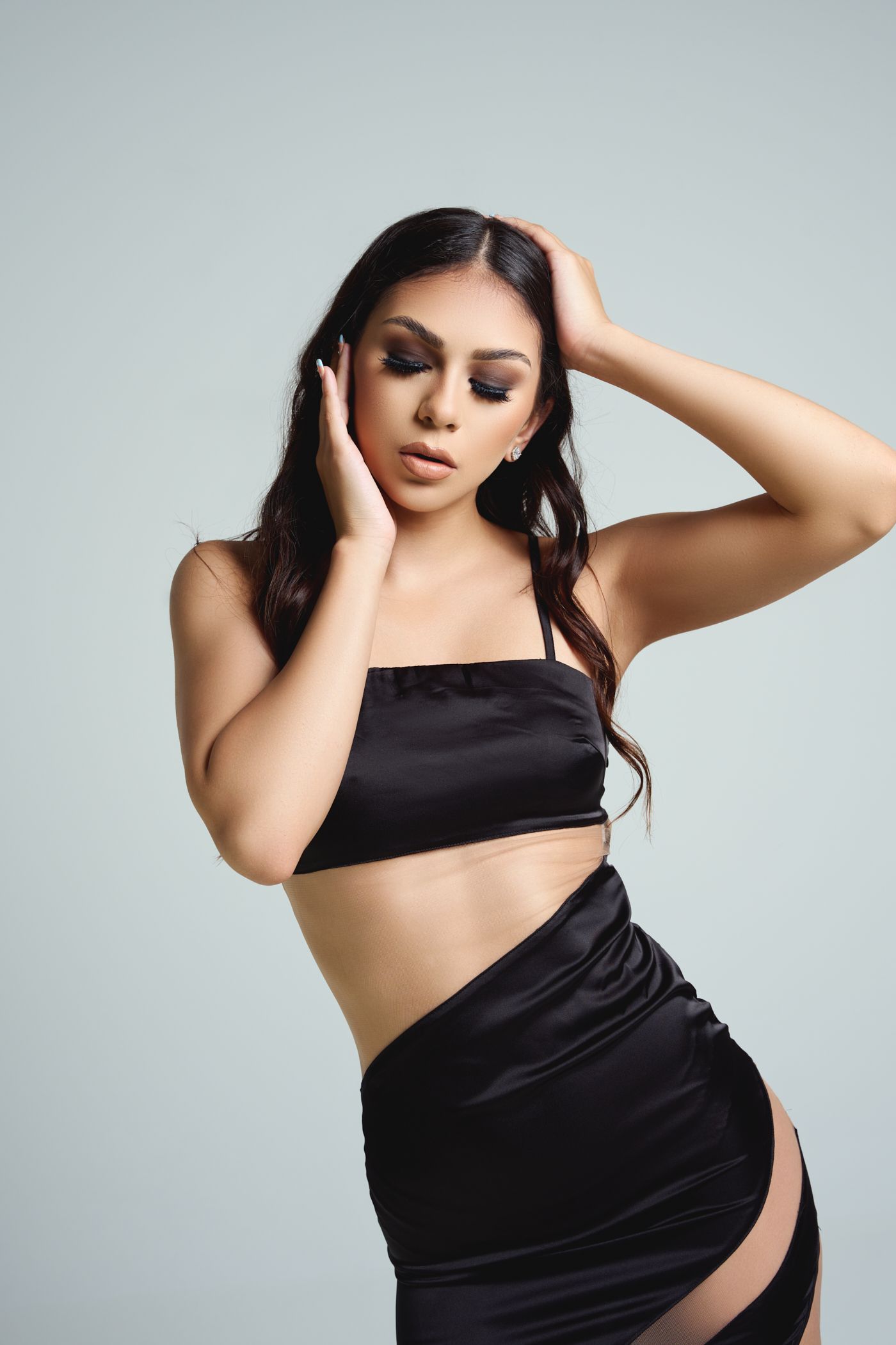 Artistic studio portraits showcasing elegant black fabric draping against a minimalist grey backdrop.