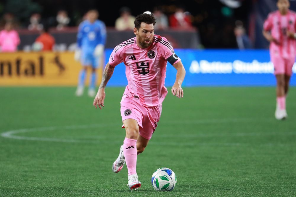 Soccer players in pink uniforms control the ball during a professional match.