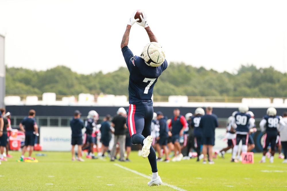 Athletes practice drills on a training field during a summer practice session.