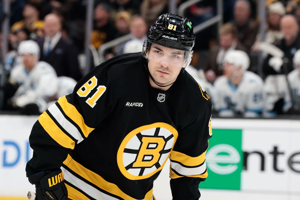 NHL players in Boston Bruins jerseys position themselves during game action.