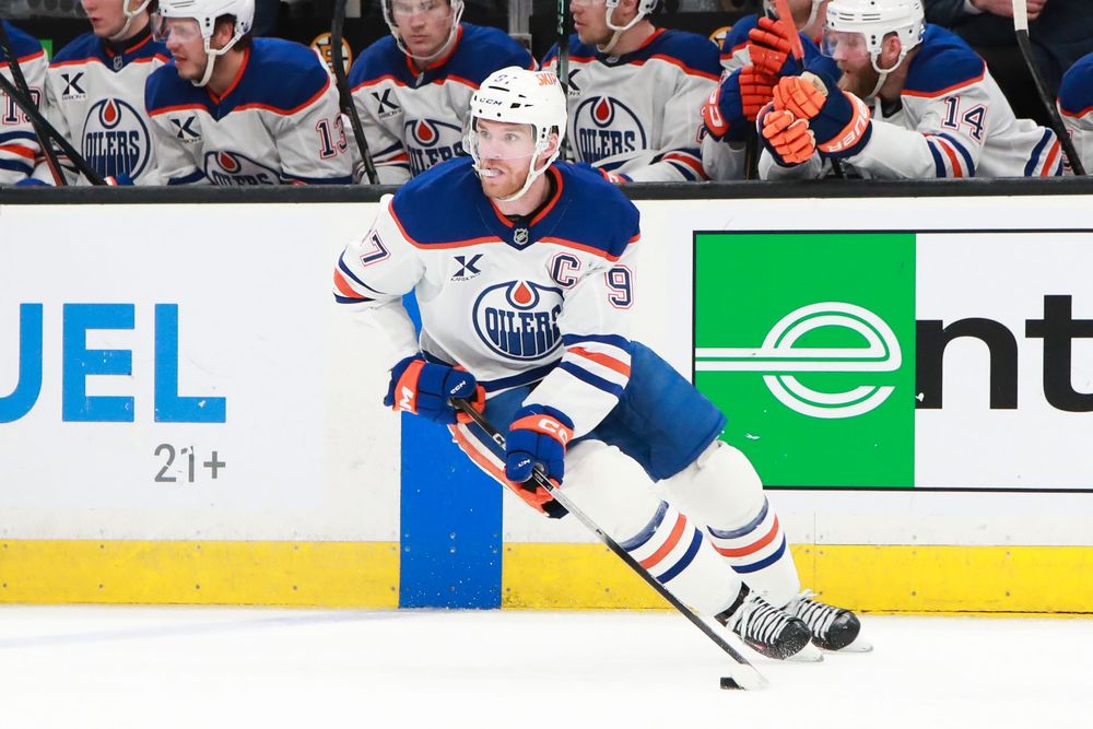 Hockey players from the Edmonton Oilers control the puck during an NHL game.