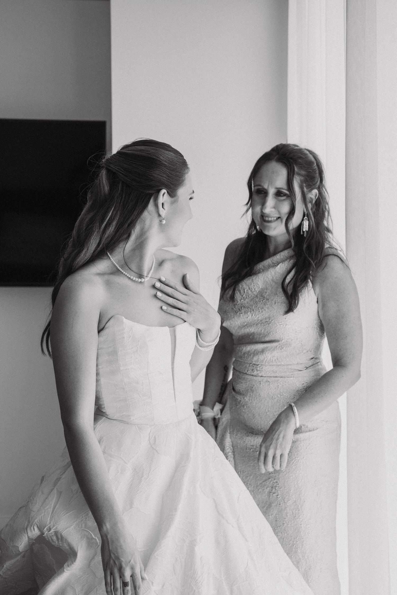 A series of black and white photos showing a heartfelt first look moment between two people in wedding attire.