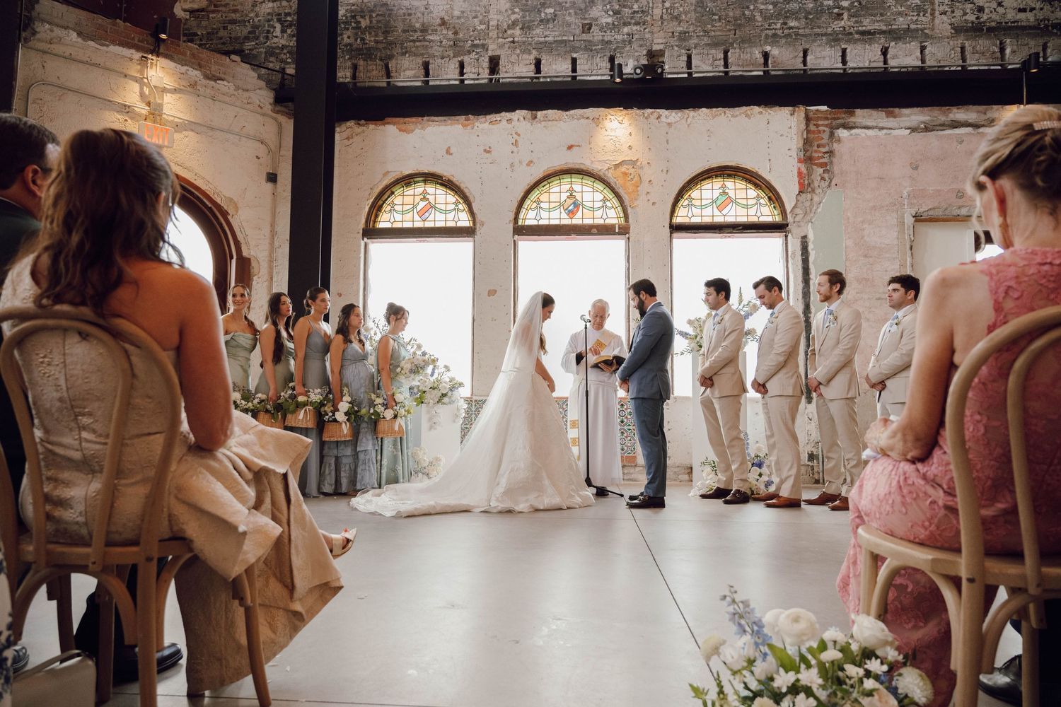 Panoramic view of a wedding ceremony space with exposed brick walls and vintage architectural details.