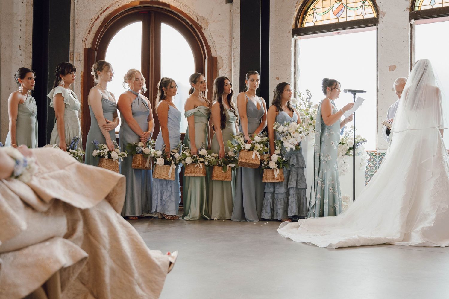Wedding ceremony venue with arched stained glass windows and exposed brick walls.