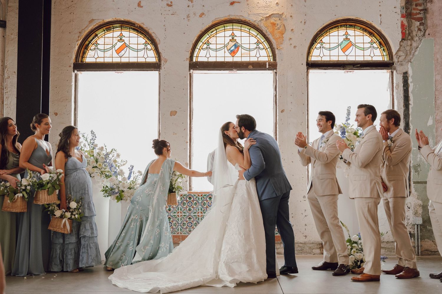 Wedding venue interior featuring exposed brick walls and elegant arched stained glass windows.