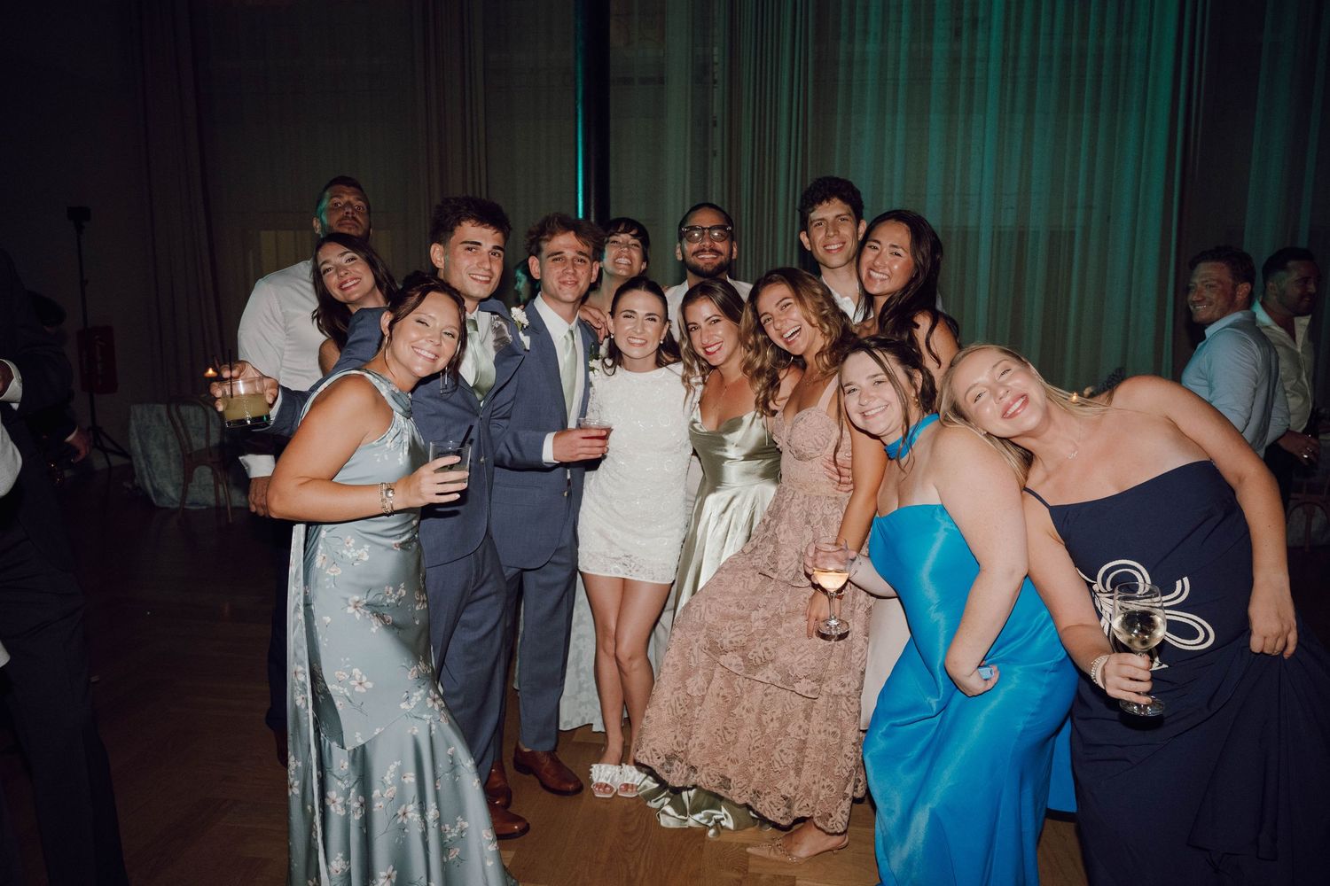 People dancing and celebrating together at a lively party with colorful lighting and festive atmosphere.