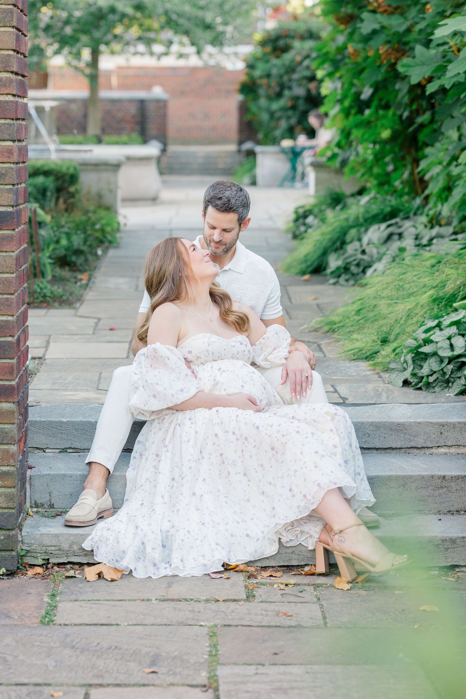 A romantic black and white photo series showing a person lying on grass wearing a delicate white lace dress.
