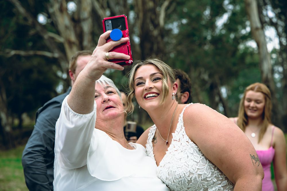 A group celebrates at an outdoor wedding ceremony with joyful expressions and laughter.