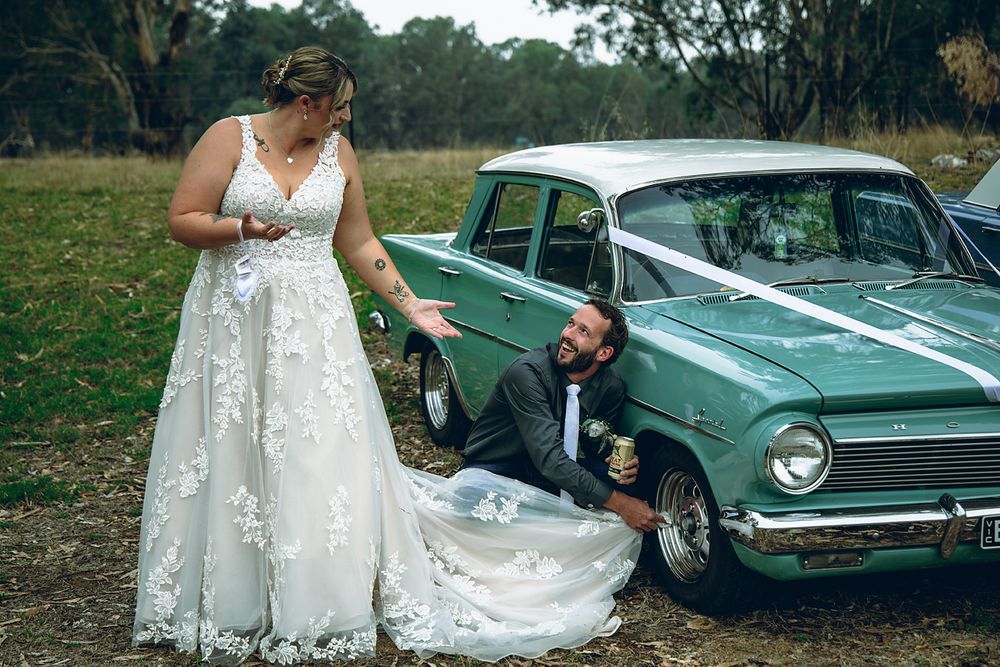 A vintage mint green car serves as a stylish backdrop for an outdoor wedding photoshoot.