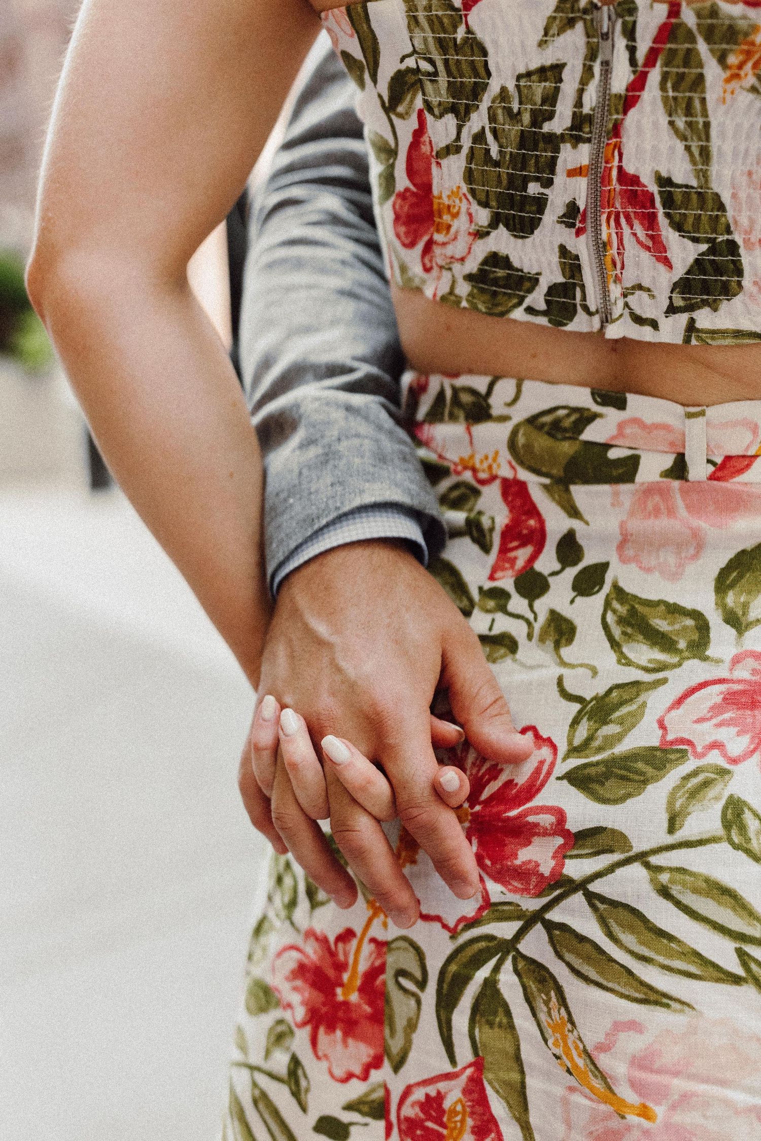 Detail shots of hands against a floral patterned dress fabric.