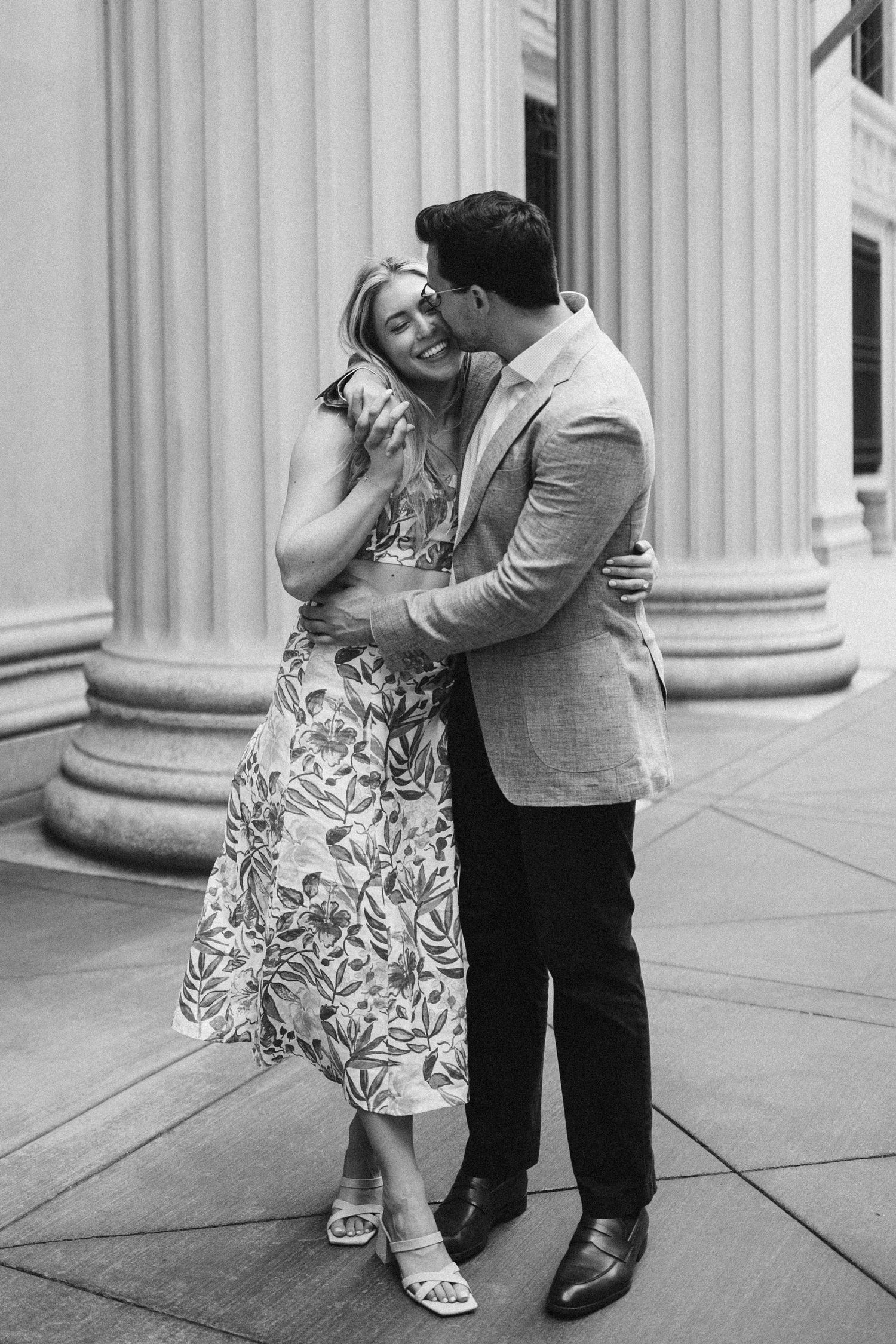 Black and white sequence of a couple dancing and embracing near architectural columns.