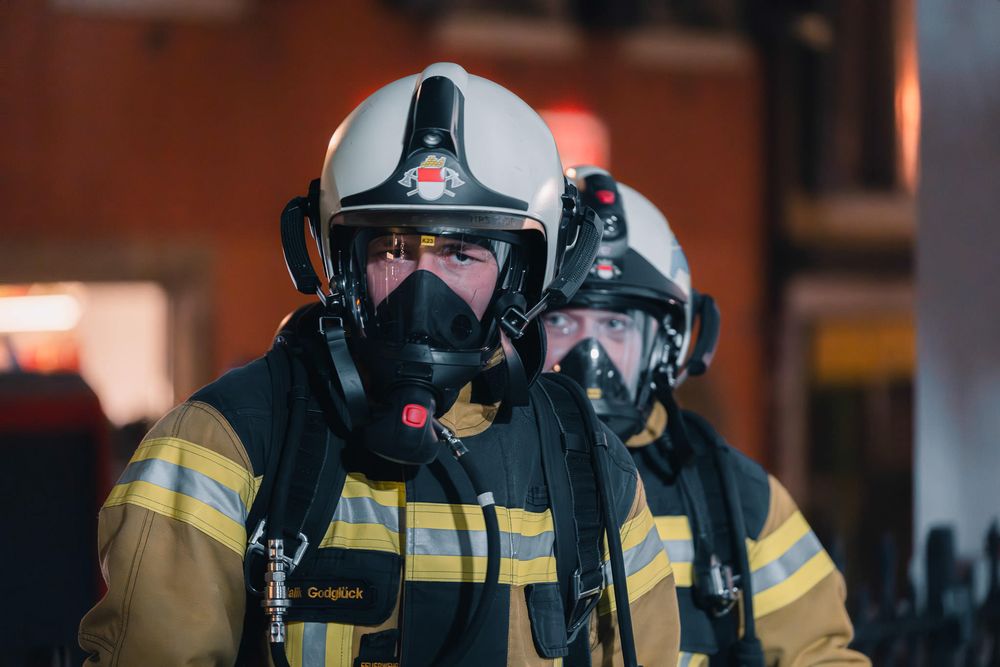 Firefighters wearing protective masks and helmets during an emergency response.