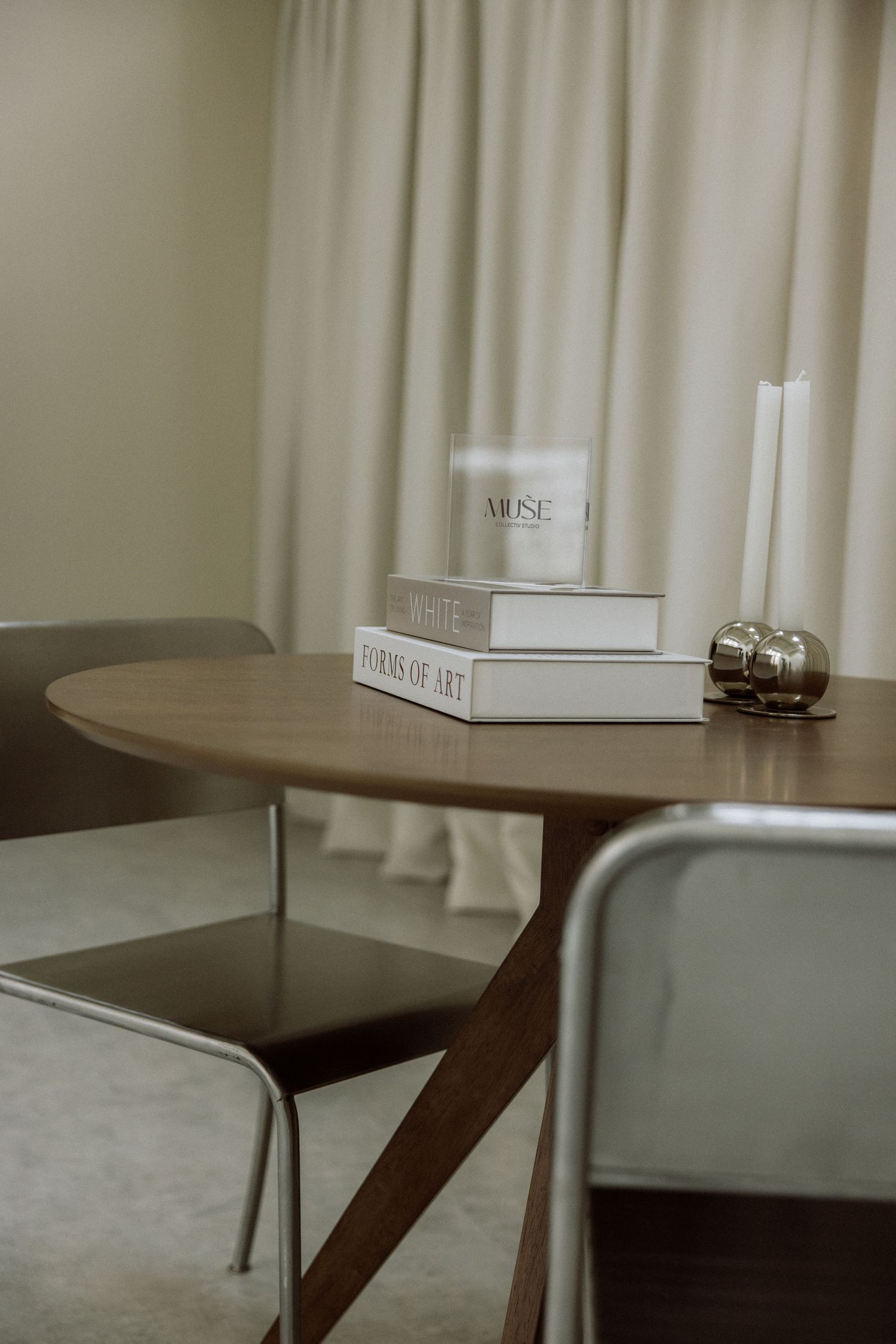Minimalist room interior with white bean bag chair, wooden panel, potted plant, and modern desk setup on concrete floor.