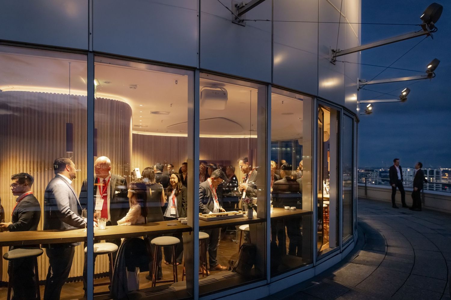Modern office space with panoramic windows during sunset or dusk.