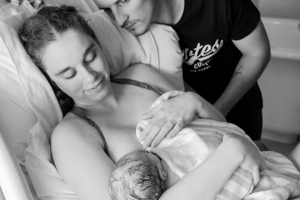 Hospital delivery room scene showing emotional support and care in monochrome during a central coast birth session.