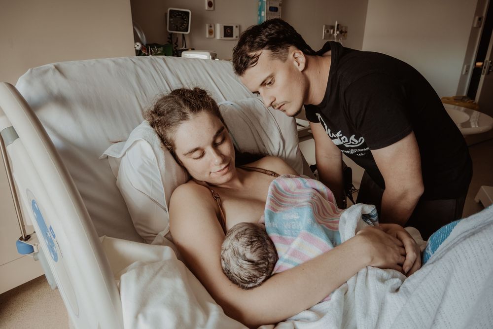 Hospital room scene showing tender moments of care and support during a central coast birth session.