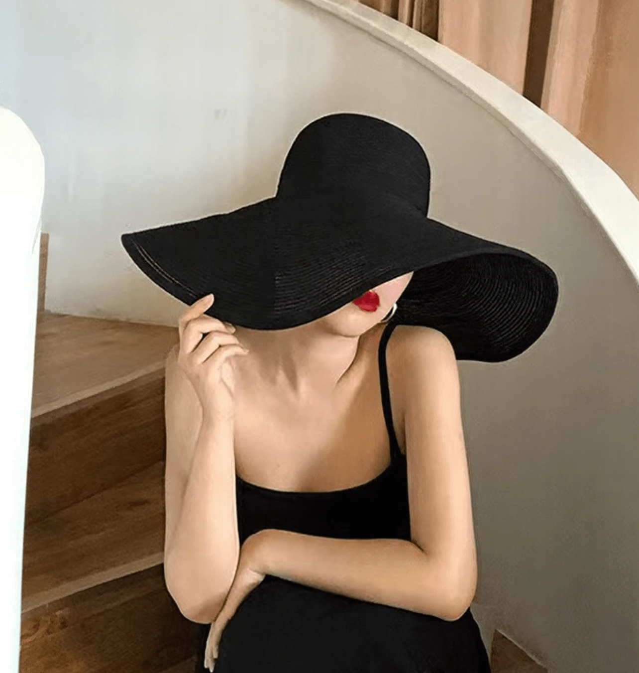 Stylish maternity portrait with black wide-brim hat and dress.